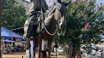 Monumental bronze sculpture of Red Steagall on horseback.
