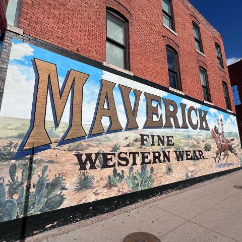 Large wall mural with cowboy on horseback.