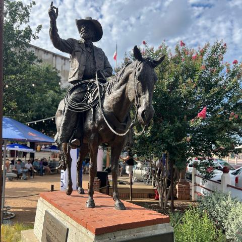 Monumental bronze sculpture of Red Steagall on horseback.