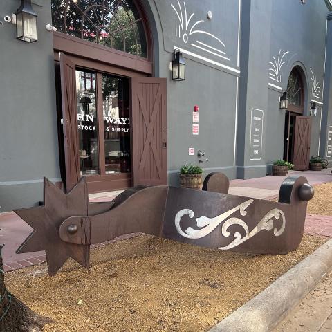 Large metal sculpture shaped like a cowboy spur.